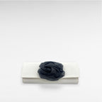 white satin clutch with black flower